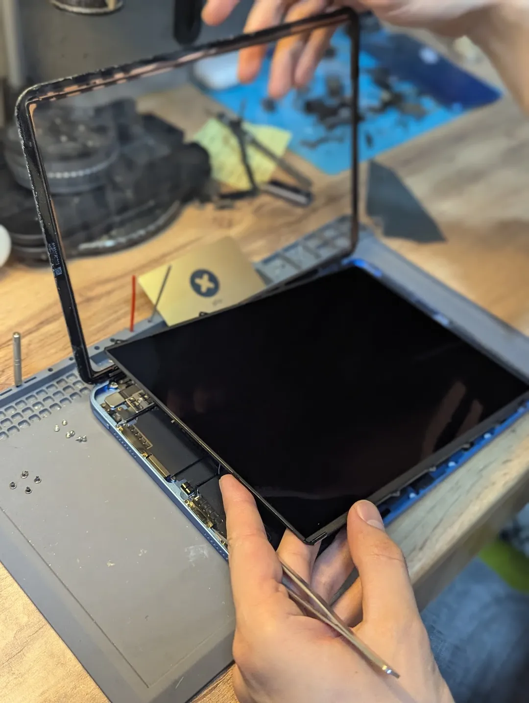 Replacing the screen of an opened iPad on an anti-static mat