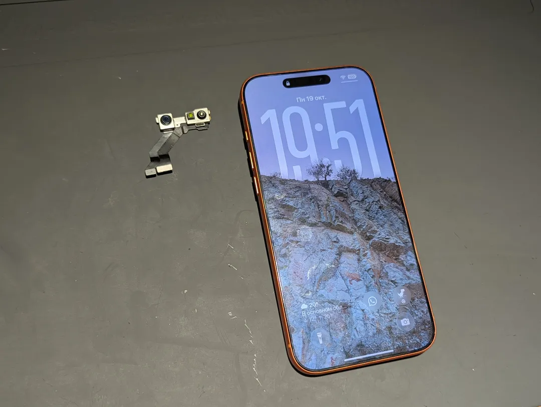 Front camera and Face ID module next to an iPhone, on an anti-static mat