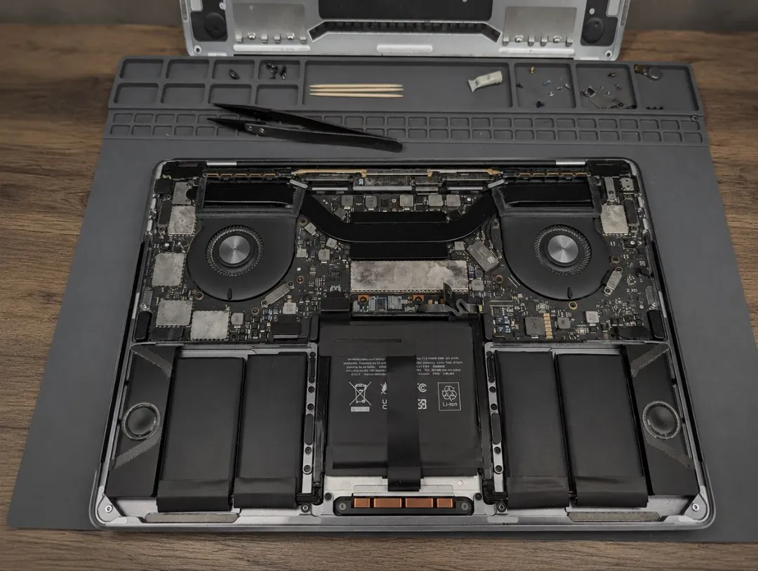 Opened MacBook Pro on a repair mat, with the battery and logic board visible