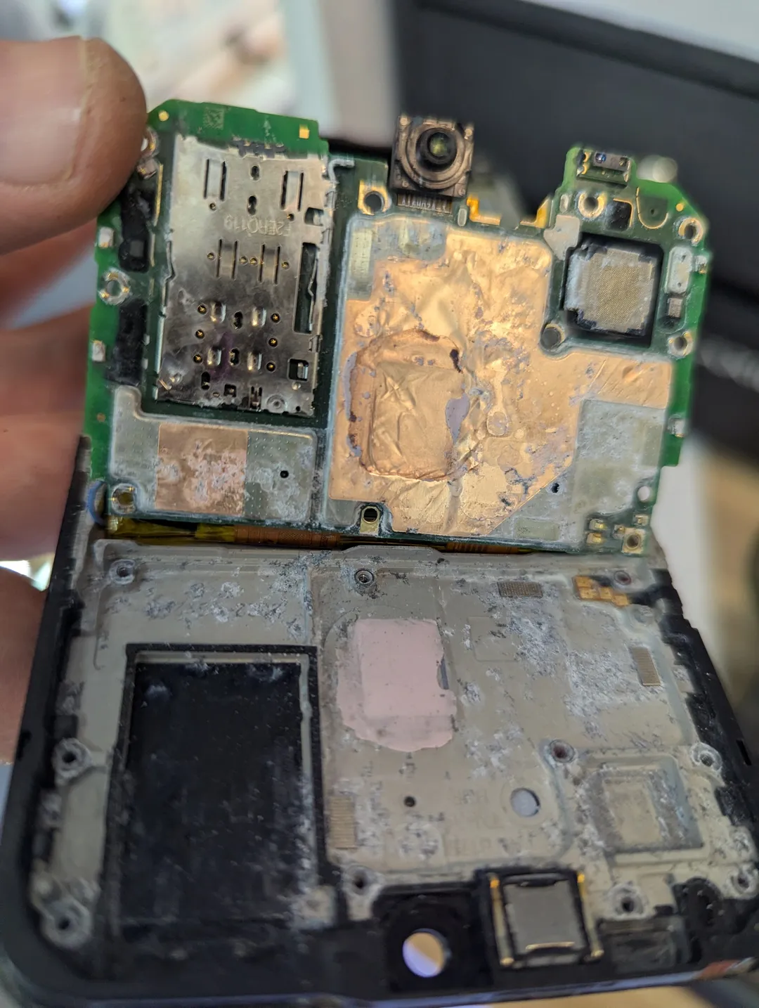 Corrosion on an opened phone's board and frame after liquid damage