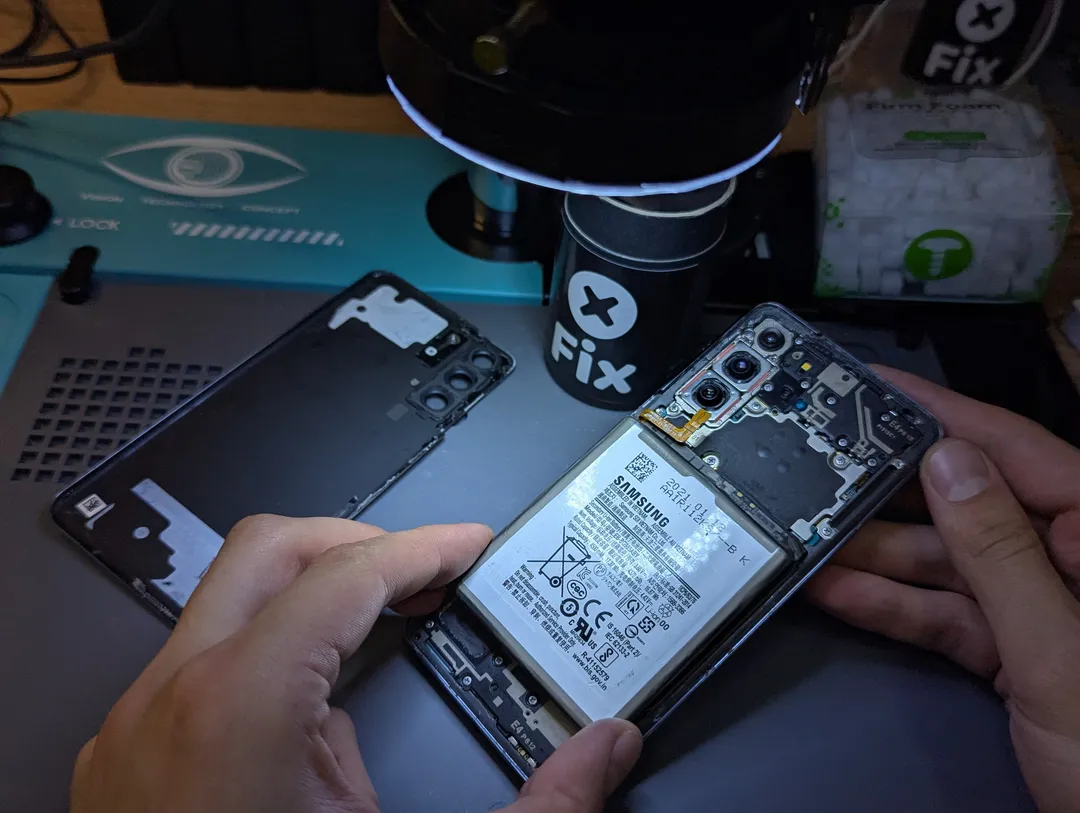 Вскрытый Samsung Galaxy с видимым аккумулятором, рядом задняя крышка