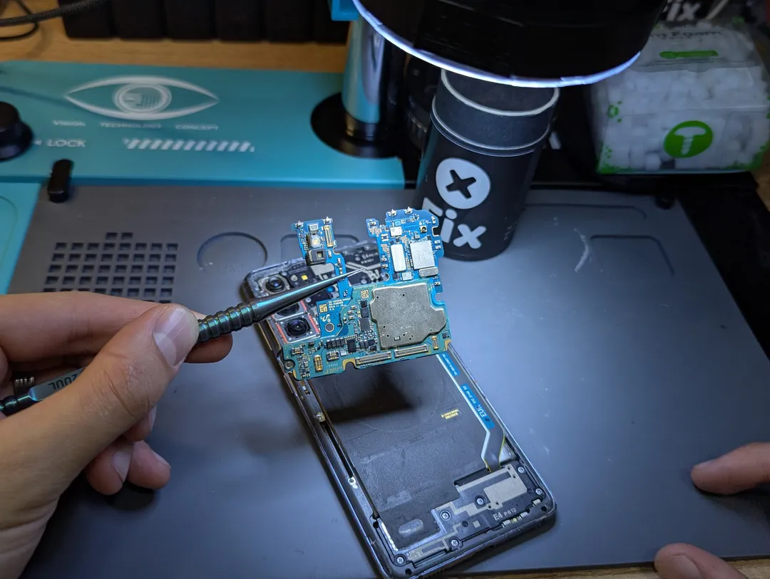 Samsung Galaxy motherboard lifted out of the phone with tweezers