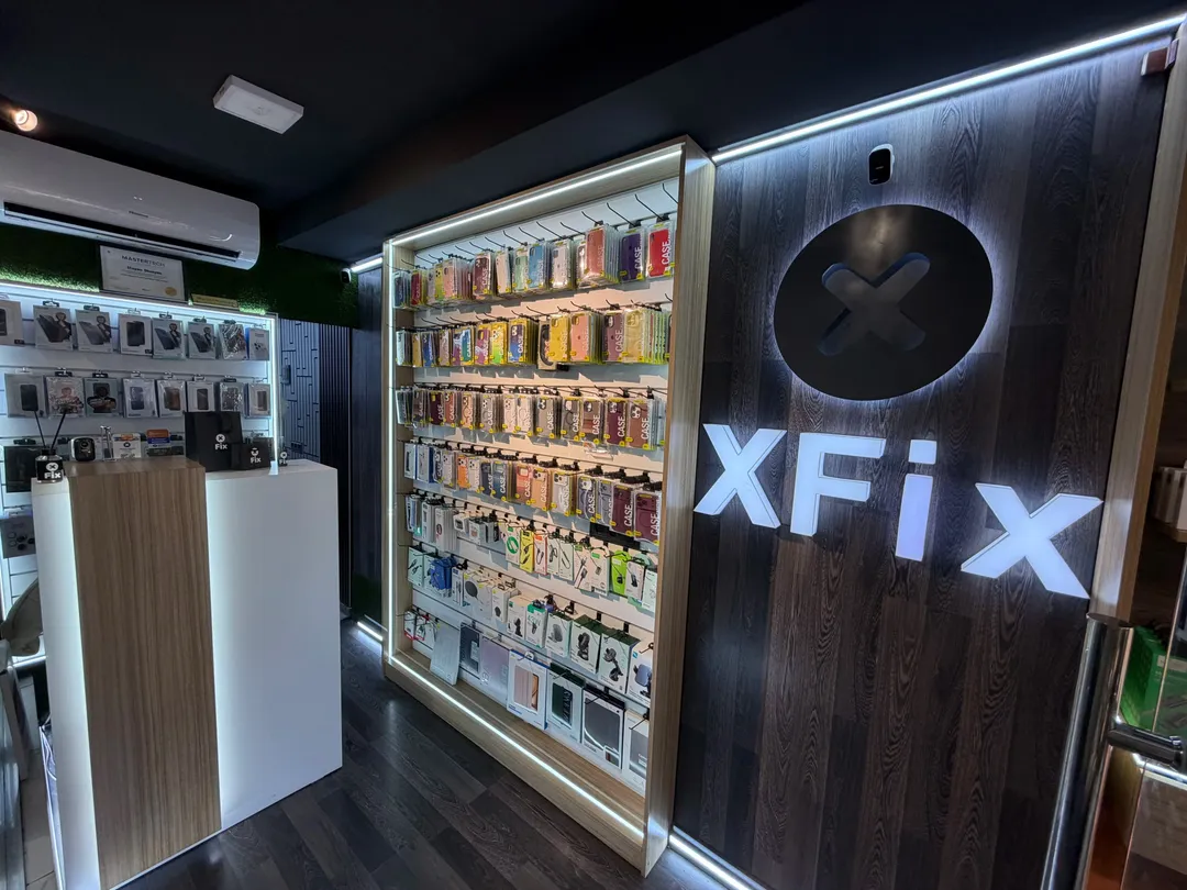 Inside the XFix shop: the counter, phone cases on the wall and the lit XFix sign